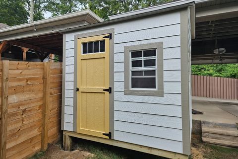 Compact 4x8 lean-to shed with painted Hardie siding against a house wall
